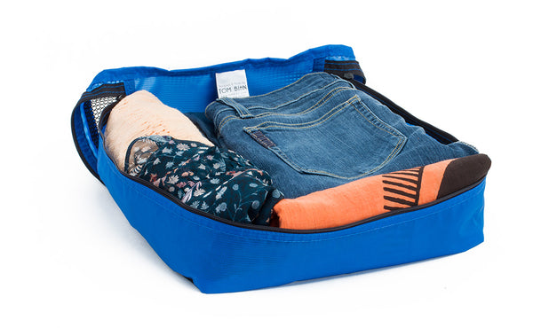 A set of clothes in an open Island (blue) Aether Large Packing Cube for the Aeronaut 30.